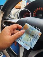 jacarta, indonésia, em julho de 2022. uma mão está segurando uma nota de cinquenta mil rúpias que se dobra durante a condução. foto