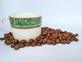 xícara de café e grãos de café no fundo branco foto