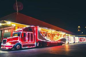 tbilisi, georgia, 2021 - visão estática, caminhão festivo de teto aberto de natal vermelho tradicional da coca cola com ursinhos de pelúcia brancos dentro. celebrações festivas de natal e veículo festivo na estrada foto