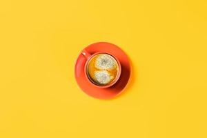 uma xícara de café sobre fundo amarelo. foto