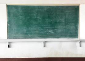 um quadro-negro para giz é montado em uma parede de cimento branco em uma sala de aula em um país pobre da ásia. foto