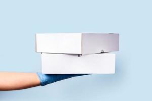 um fundo azul com as duas mãos segurando uma caixa de comida. foto