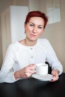 mulher tomando café da manhã, na mesa foto