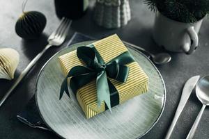 configuração de mesa de natal ou ano novo. prato azul artesanal com talheres em fundo de pedra cinza. fechar-se foto