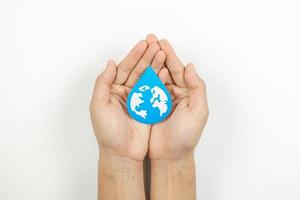 mãos segurando corte de papel de gota de água, lavando as mãos, desinfetante para as mãos e higiene. dia mundial da água, economia de água e conceito mundial de proteção ambiental foto