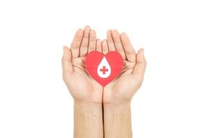 mãos segurando papel de gota de sangue cortado em fundo branco, transfusão de sangue, dia mundial do doador de sangue. doação de sangue e salvando o conceito de vida foto