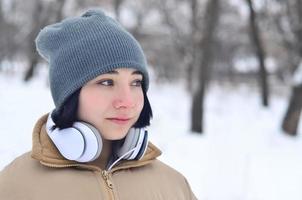 retrato de inverno de jovem com fones de ouvido foto