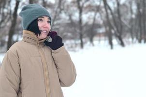 retrato de inverno de jovem com smartphone foto