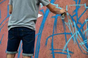 kharkov, ucrânia - 27 de maio de 2017 festival de artes de rua. jovens desenham grafite em paredes de madeira portáteis no centro da cidade. o processo de pintura em paredes com latas de aerossol foto