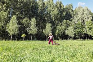 retrato de uma jovem loira treinando um cão de caça da raça kurz-haar no parque. férias de verão foto