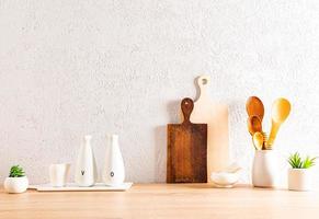 fundo de cozinha moderna com utensílios em uma bancada de madeira contra a parede texturizada. espaço para texto. itens ecológicos. foto