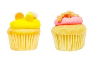 cupcake com creme de morango e cobertura de açúcar mascavo e cupcake amarelo ou abacaxi isolado em fundo branco com traçado de recorte. padaria doce fresca assada e caseira. sobremesa colorida. foto