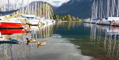 barcos à vela coloridos no porto no lago de montanha no outono, lago de garda, Itália foto