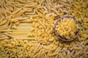 macarrão cru vários tipos de macarrão cru macarrão espaguete e macarrão, conceito culinário de comida italiana, coleção de diferentes massas cruas na mesa de cozimento para cozinhar alimentos foto