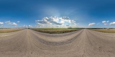 visão panorâmica hdri 360 esférica sem costura completa em estrada de cascalho sem tráfego entre campos com céu nublado e nuvens brancas em projeção equiretangular, pode ser usado como substituto do céu em panoramas foto