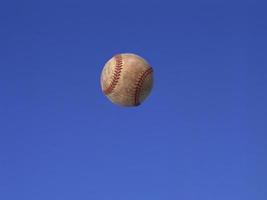 uma bola de futebol disparada no ar com fundo de céu azul foto