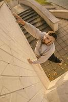 um jovem supera obstáculos, escalando paredes de concreto. o atleta pratica parkour, treinando em condições de rua. o conceito de subculturas esportivas entre os jovens foto