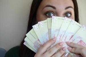 retrato de menina morena caucasiana com grande quantidade de dinheiro ucraniano foto
