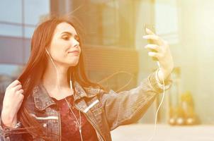 jovem garota fazendo selfie no fundo de um prédio de escritórios foto