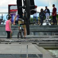 um ciclista salta sobre um cano em uma bicicleta bmx. muitas pessoas com bicicletas ao fundo. conceito de esportes radicais foto