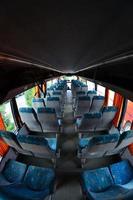 interior do ônibus turístico para excursões e viagens longas. muitos assentos gratuitos e lugares para bagagem pequena foto