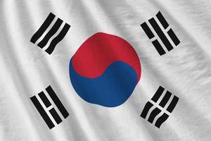 bandeira da coreia do sul com grandes dobras acenando perto sob a luz do estúdio dentro de casa. os símbolos e cores oficiais no banner foto
