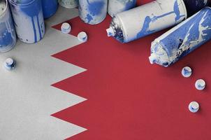 bandeira do bahrein e algumas latas de spray aerossol usadas para pintura de graffiti. conceito de cultura de arte de rua foto