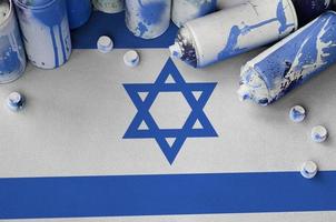 bandeira de israel e algumas latas de spray aerossol usadas para pintura de grafite. conceito de cultura de arte de rua foto