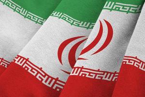 bandeira do irã com grandes dobras acenando de perto sob a luz do estúdio dentro de casa. os símbolos oficiais e cores no banner foto