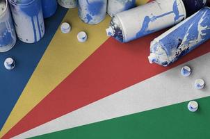 bandeira de seychelles e algumas latas de spray de aerossol usadas para pintura de grafite. conceito de cultura de arte de rua foto