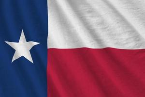 bandeira do estado do texas eua com grandes dobras acenando perto sob a luz do estúdio dentro de casa. os símbolos e cores oficiais no banner foto