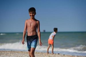 dois irmãos jogam pedras no mar na praia porto sant elpidio, itália. foto