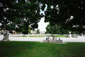 descanso familiar no parque com canal na praça prato della valle e basílica santa giustina em padova, veneto, itália. foto