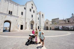 família de turistas contra a basílica de são nicolau em bari, igreja católica, puglia, sul da itália. foto