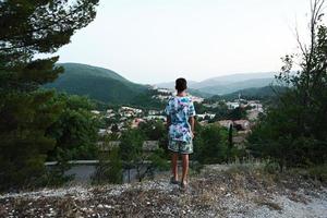 as costas do menino ficam de pé e olham em vista de nocera umbra, cidade e comuna na província de perugia, itália. foto