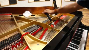 jacarta, 2 de novembro de 2022 - indonésio. um homem cuidando de um piano clássico com um fundo desfocado fornecido para a área de texto da sala de recital com ornamentos de batik foto