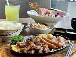 vários menus, sushi, sashimi, nigiri, carne de porco frita e sopa de missô. sashimi, sashimi chutoro, pauzinhos de comida japonesa e wasabi na mesa preta, estilo de comida japonesa. desfoca o foco. foto