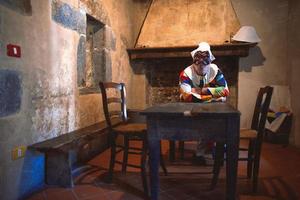 a máscara de Arlecchino. sentado na mesa de uma casa velha foto