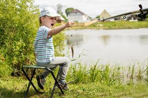 criança pescando no lago foto