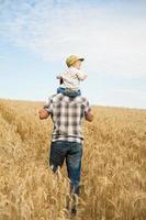 homem andando com seu filho no campo foto