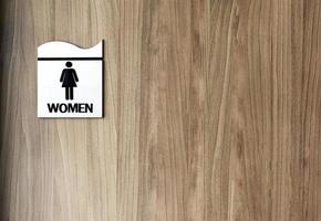 porta de banheiro de madeira com sinal nele mulher de texto. copie o espaço foto