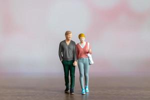 pessoas em miniatura homem e mulher em pano casual juntos em fundo rosa foto