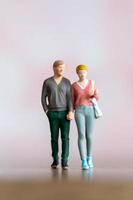 pessoas em miniatura homem e mulher em pano casual juntos em fundo rosa foto