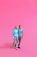 pessoas em miniatura homem e mulher em pano casual juntos em fundo rosa foto