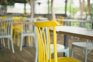 close-up de cadeiras de madeira em um bar. foco seletivo em uma cadeira amarela de perto. visualização de barra, desfoque de foco, ideia de decoração de barra ou foto para interior