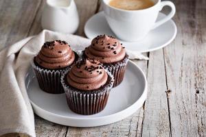 cupcakes de chocolate com uma xícara de café foto