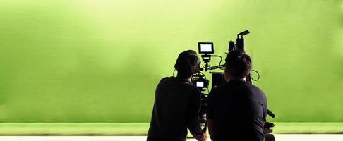câmera e estúdio de tela verde em vista panorâmica e homem trabalhando ou filmando ou gravando ou filmando. foto