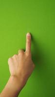 dedo humano tocando ou apontando no fundo da tela verde e no estúdio. foto