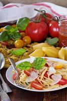 espaguete com tomate cereja, manjericão e parmesão foto