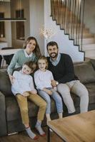 família feliz com dois filhos aproveitam o tempo juntos no sofá na sala de estar foto